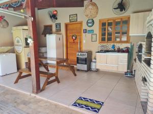 uma cozinha com uma mesa e um frigorífico em Rancho da Malu em Taubaté