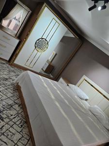 1 dormitorio con cama y espejo grande en BONUSHKA 5* en Samarcanda