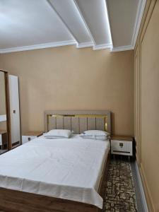 サマルカンドにあるBONUSHKA 5*のベッドルーム(白いシーツを使用した大型ベッド1台付)