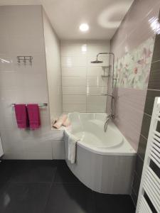 a white bath tub in a bathroom with purple towels at Kuća za odmor EMA in Šibenik