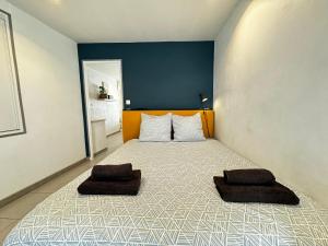 a bedroom with a bed with two pillows on it at Le Cocon Citadin in Avignon