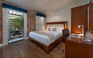 1 dormitorio con cama, escritorio y ventana en Riviera Beach House, en Santa Bárbara