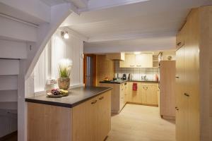 uma cozinha com armários de madeira e uma tigela de fruta no balcão em Grosses Apartment am schönen Brienzersee em Brienz