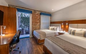 a bedroom with two beds and a desk and a window at Riviera Beach House in Santa Barbara