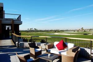 a patio with a couch and chairs and a golf course at Roda Golf. Poolside apartment in Murcia