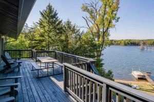 una terraza con un banco y una mesa en una casa en 4 Seasons Lakehouse Luxury, en Waupaca