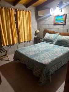 1 dormitorio con 1 cama con edredón azul en Cabañas Los Frutales en Santa María