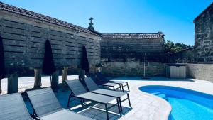 a group of chairs sitting next to a swimming pool at Lar de Canedo in Carnota