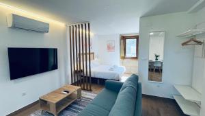 a living room with a blue couch and a bed at Lar de Canedo in Carnota
