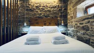 1 dormitorio con 1 cama con toallas en Lar de Canedo en Carnota