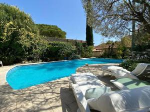 a swimming pool with lounge chairs and a swimming pool at La petite palmeraie in Fréjus