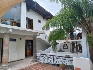 Biały dom z palmą przed nim w obiekcie SOLACHE INN w mieście Zitácuaro