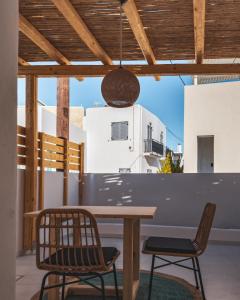 eine Terrasse mit einem Holztisch und 2 Stühlen in der Unterkunft Alonia Suites in Naoussa