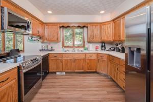 cocina con armarios de madera y nevera de acero inoxidable en Pine, en Appleton