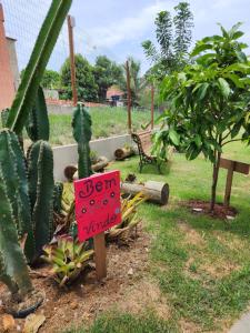 un cartel en un jardín con un montón de cactus en Pousada Canto do Sabiá en Piúma