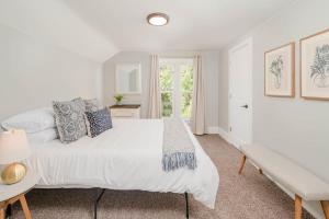 ein weißes Schlafzimmer mit einem Bett und einer Bank in der Unterkunft Bowen Street Bungalow - 3 bed 2 bath in Oshkosh