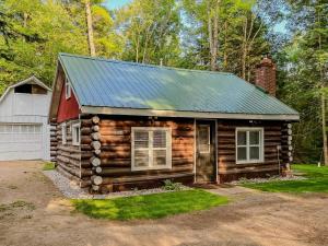 a log cabin with a tin roof and a garage at Cozy Cabin w Fireplace and Sauna in Mountain