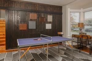 - une table de ping-pong dans une pièce avec une raquette de ping-pong dans l'établissement Lilac, à Appleton