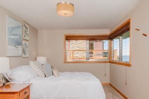 ein Schlafzimmer mit einem weißen Bett und einem Fenster in der Unterkunft Stay at Sunset Shoreline Lakehouse in Oshkosh