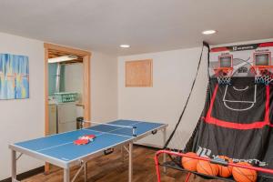 a room with a ping pong table and a net at Stay at Sunset Shoreline Lakehouse in Oshkosh