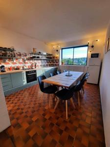 une grande cuisine avec une table et des chaises en bois dans l'établissement La maison du bord, à Bellac