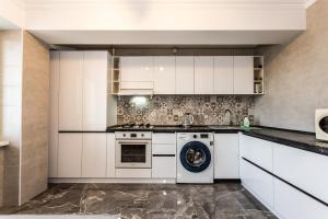 een keuken met witte kasten en een vaatwasser bij Apartment For You in Chişinău