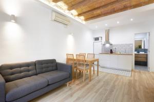 バルセロナにあるRo Lively and bright apartment next to Blai stのリビングルーム(ソファ、テーブル付)、キッチンが備わります。