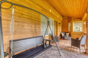 eine Veranda eines Holzhauses mit Schaukel in der Unterkunft Iron Mountain - Spacious Secluded Lodge with Hot Tub & Game Room in Sandy