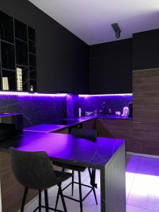 eine Küche mit lila Beleuchtung in einem schwarzen Raum in der Unterkunft Luxury Penthouse Sarajevo in Sarajevo