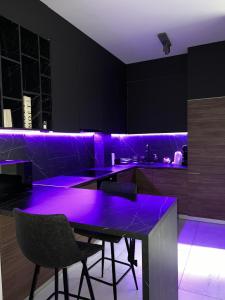 une cuisine avec un éclairage violet dans une pièce noire dans l'établissement Luxury Penthouse Sarajevo, à Sarajevo