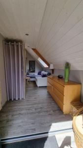 ein Wohnzimmer mit einem Sofa im Dachgeschoss in der Unterkunft Ancien moulin près d'un ruisseau in Sallen