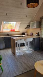 eine Küche mit zwei Barhockern und einer Theke in der Unterkunft Ancien moulin près d'un ruisseau in Sallen