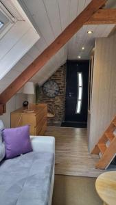um quarto com um sofá e uma escada com um relógio em Ancien moulin près d'un ruisseau em Sallen