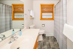 Baño blanco con lavabo y aseo en - 3 bedroom 2 bath, en Appleton