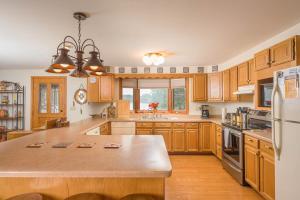 a large kitchen with wooden cabinets and a large island at Lake House Vacation Sleeps 12 Private Dock in Waupaca