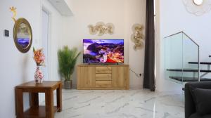 een woonkamer met een televisie op een houten kast bij Urban Oasis Retreat Transit - 2BR duplex in Abu Dhabi