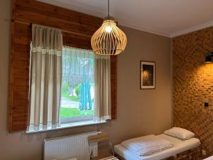 a room with a window with a bed and a pendant light at Latarnia Wagabundy Bieszczady in Wola Michowa