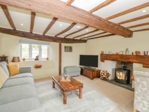 a living room with a couch and a fireplace at Forever Home in Honiton