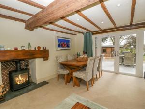 a dining room with a fireplace and a table and chairs at Forever Home in Honiton