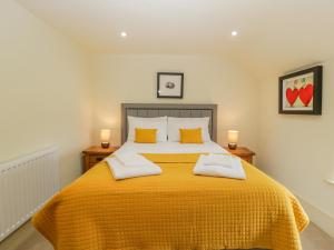 a bedroom with a yellow bed with two pillows at Forever Home in Honiton
