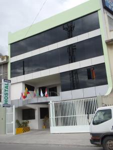 a building with large windows with flags on it at Hospedaje Fenix in Cuenca