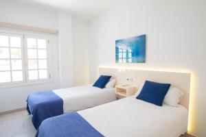 een slaapkamer met 2 bedden en een raam bij Blancazul Alto Brisa in Playa Blanca