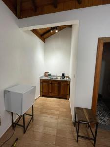 an empty kitchen with a sink and a table at Suítes Encanto de Minas in Tiradentes