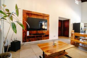 salon ze stołem i telewizorem w pokoju w obiekcie Cocoon CoLive Nosara w mieście Nosara