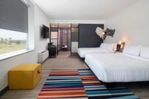 a hotel room with two beds and a window at Aloft McAllen in McAllen