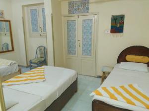 um quarto com 2 camas e uma cadeira em ONE NATION HOTEL Luxor em Luxor