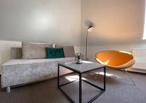ein Wohnzimmer mit einem Sofa, einem Stuhl und einem Tisch in der Unterkunft Casa in Hradec Králové
