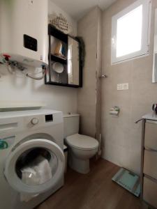 ein Badezimmer mit einem WC und einer Waschmaschine in der Unterkunft Motril Carpe Diem Primera línea de playa in Motril