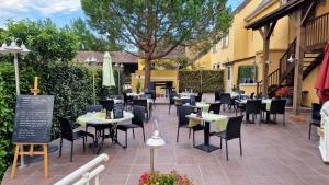 a patio at a restaurant with tables and chairs at Hôtel Saint Jacques in Thorigné-sur-Dué