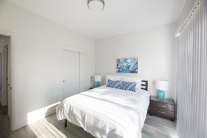 a white bedroom with a large bed and two night stands at Sonoma Grove Suites in Sonoma